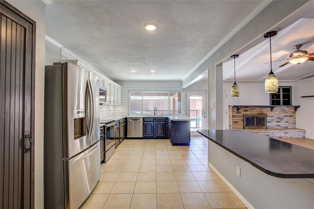5233 Reed Drive The Colony, TX 75056 - Photo 25 of 40 a large kitchen with a large counter top stainless steel appliances and cabinets