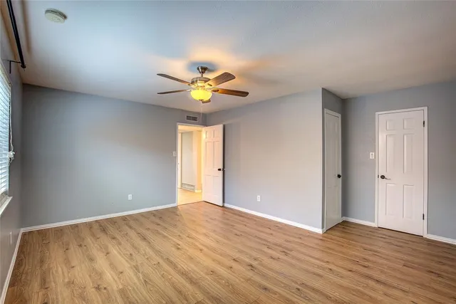 an empty room with wooden floor and window