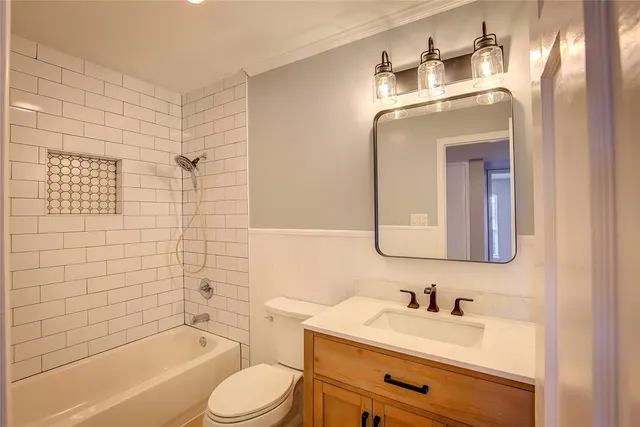 a bathroom with a toilet sink vanity tub and shower