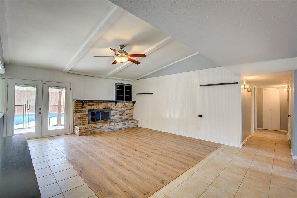5233 Reed Drive The Colony, TX 75056 - Photo 8 of 40 a view of a livingroom with a fireplace a ceiling fan and windows
