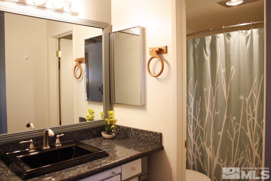 233 Clubhouse Circle Stateline, NV 89449 - Photo 5 of 28 a bathroom with a granite countertop sink and a mirror