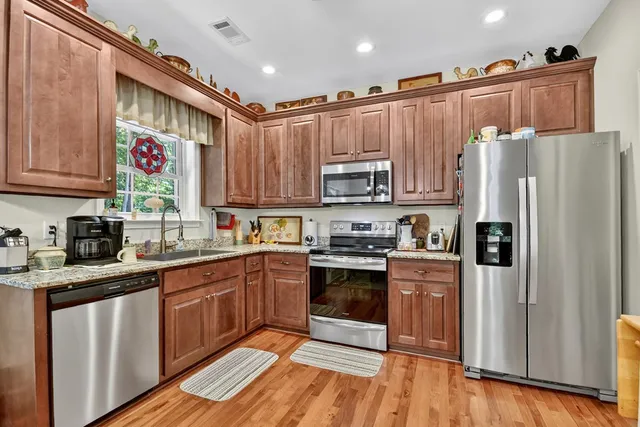 a kitchen with stainless steel appliances granite countertop a refrigerator sink and cabinets