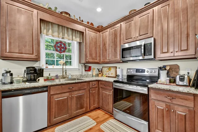 a kitchen with stainless steel appliances granite countertop a sink stove and cabinets