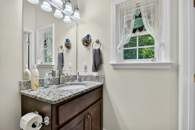 a bathroom with a granite countertop sink and a mirror