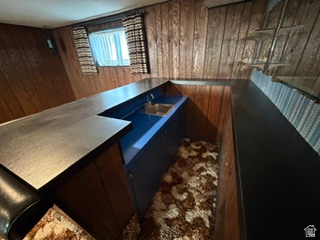 588 North 4500 West West Point, UT 84015 - Photo 30 of 61 Lower-level space featuring wood paneling, a built-in bar with a sink, and a patterned carpet