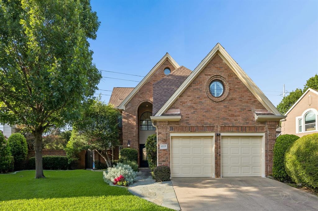 Brick exterior with a prominent arched entry and a two-car garage