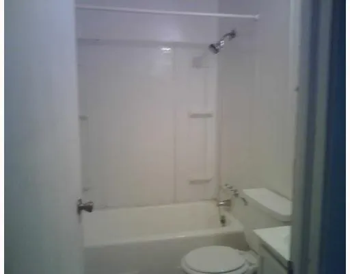 a view of an empty room with closet and a window