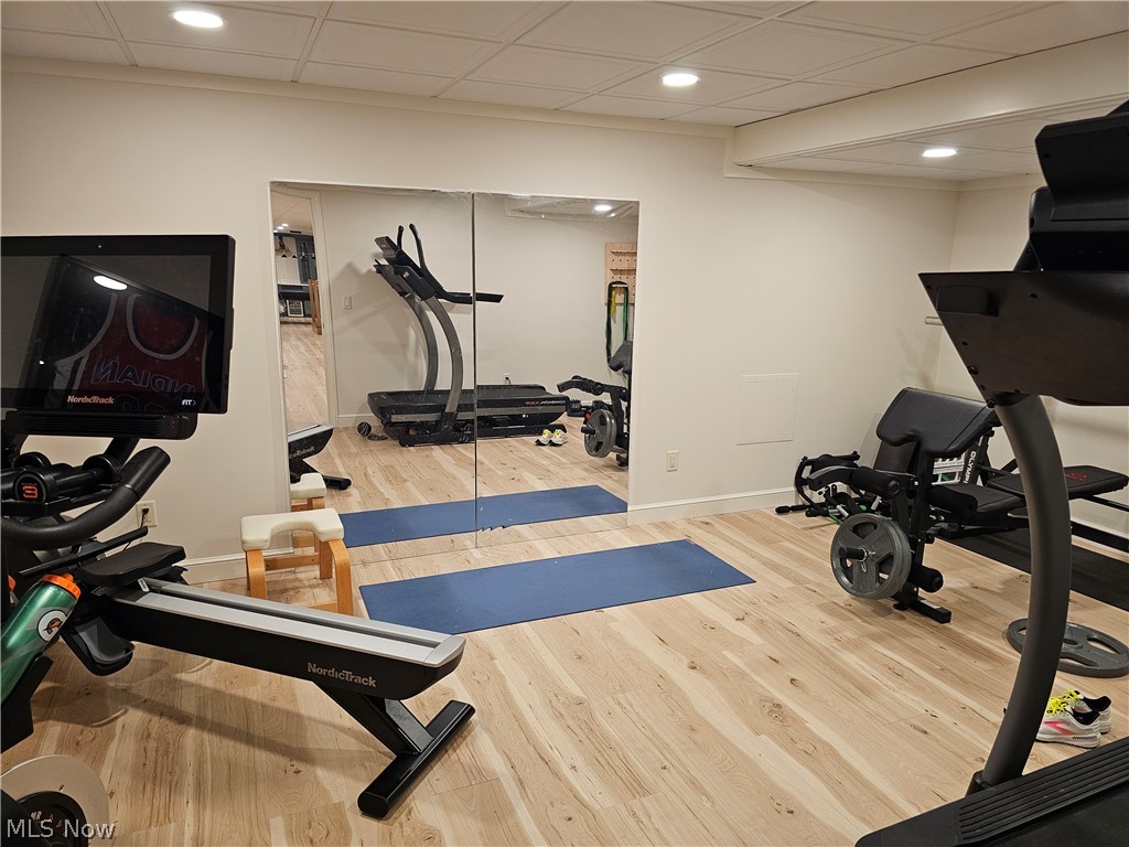 2363 Tabor Ridge Road Northeast New Philadelphia, OH 44663 - Photo 35 of 42 Dedicated fitness space featuring light wood-finish flooring, recessed lighting, expansive mirrored wall, and white baseboards