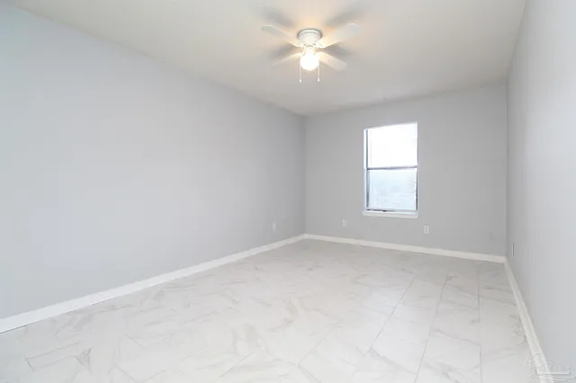 an empty room with a window and a fan