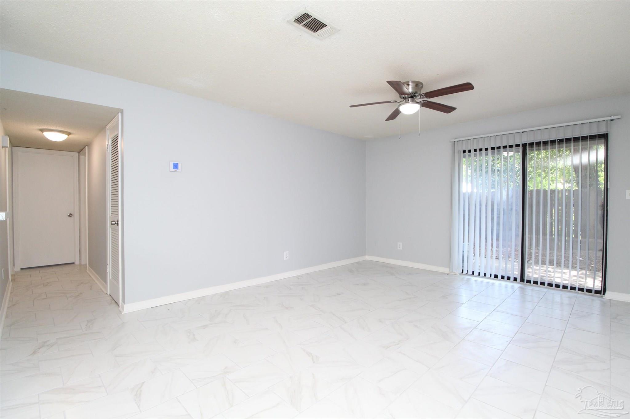7116 Pearson Road, Unit C Pensacola, FL 32526 - Photo 4 of 20 an empty room with a ceiling fan and windows