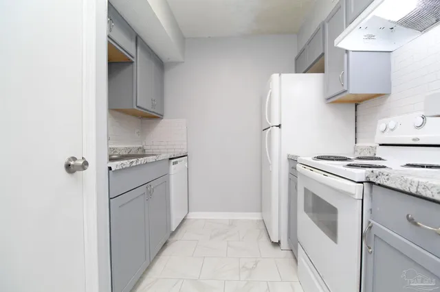 a kitchen with stainless steel appliances granite countertop a refrigerator and a stove