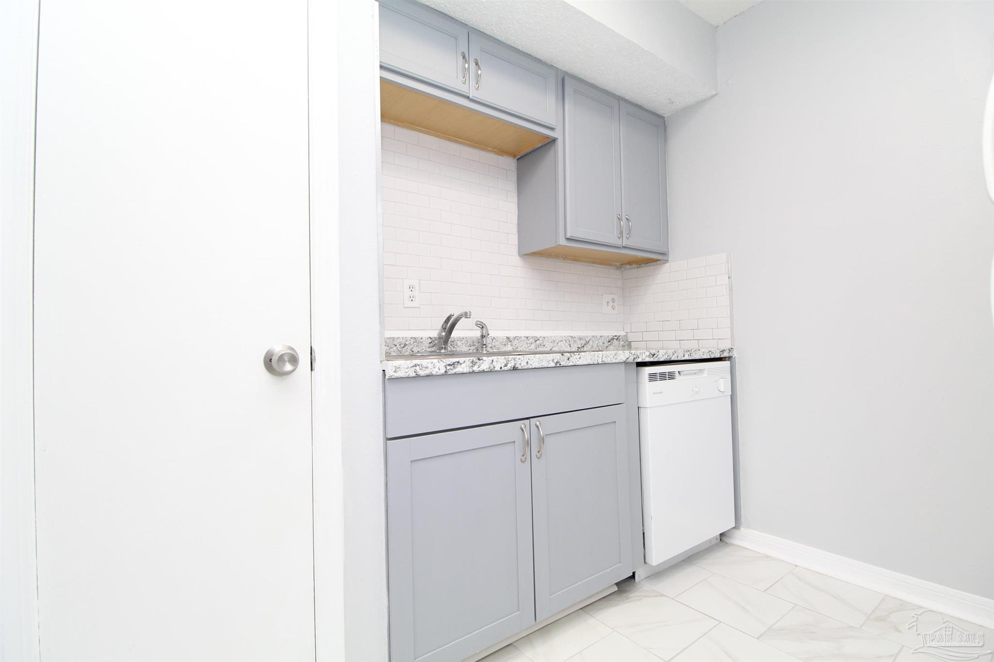 7116 Pearson Road, Unit C Pensacola, FL 32526 - Photo 9 of 20 a kitchen with white cabinets and white appliances