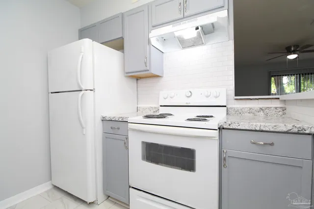 a kitchen with stainless steel appliances granite countertop white refrigerator sink and stove