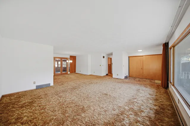 a view of a room with a ceiling fan and window