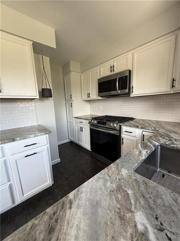 1681 Robbins Station Road Irwin, PA 15642 - Photo 15 of 27 a kitchen with stainless steel appliances granite countertop a stove a sink and a microwave