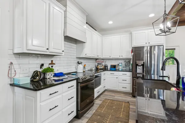 a kitchen with stainless steel appliances granite countertop a refrigerator sink and cabinets