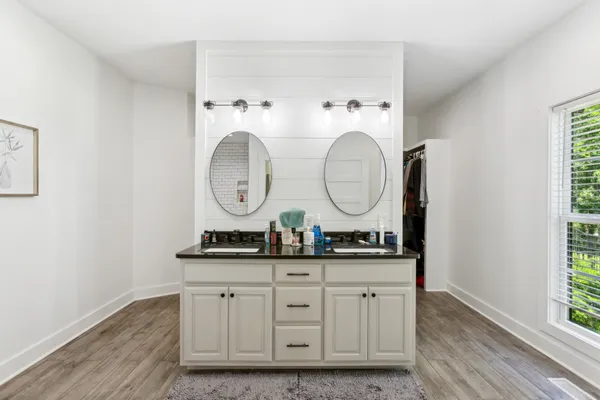 a room with round mirror and clock on the wall