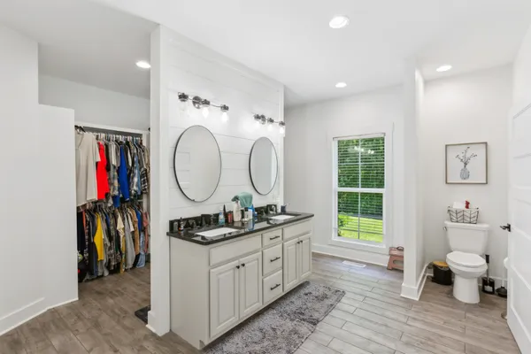 a bathroom with a double vanity sink mirror and toilet
