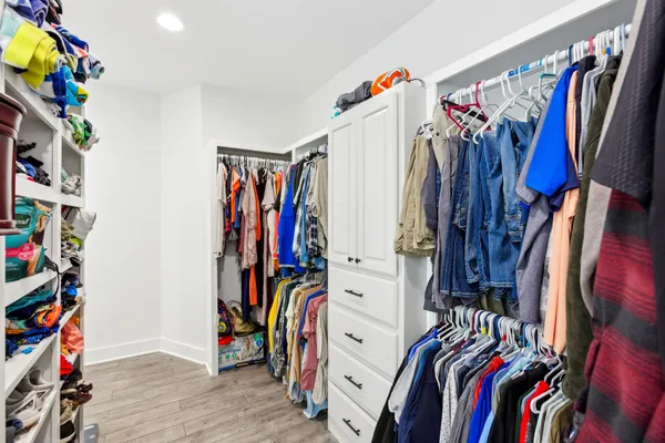 a view of walk in closet with clothes