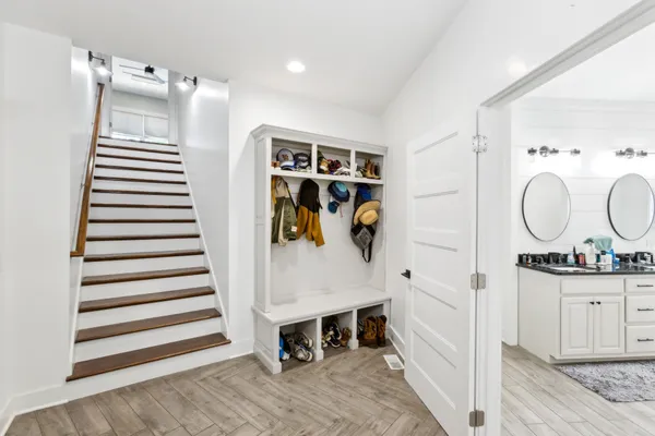 a view of a kitchen with stainless steel appliances wooden floor and entryway