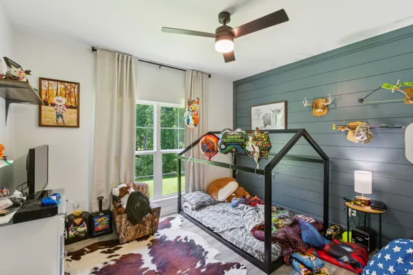 a living room with furniture a flat screen tv and a window