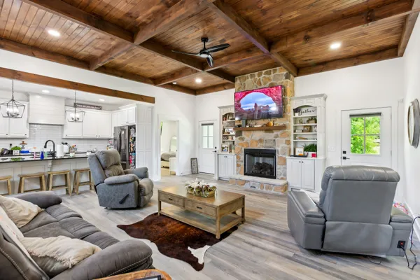 a living room with furniture a fireplace and a chandelier
