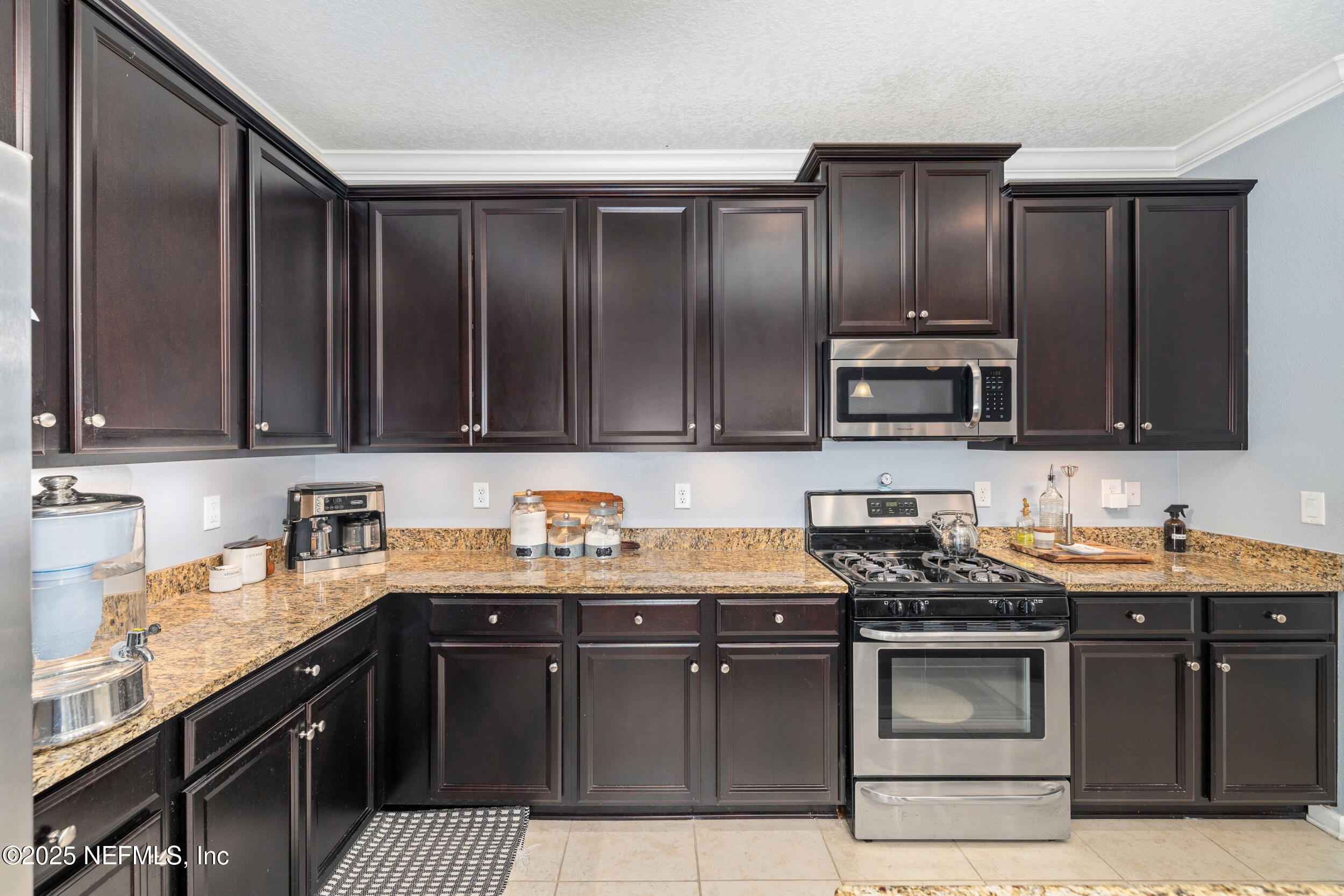 221 St Kitts Loop St. Augustine, FL 32092 - Photo 11 of 44 a kitchen with stainless steel appliances granite countertop a sink stove and microwave