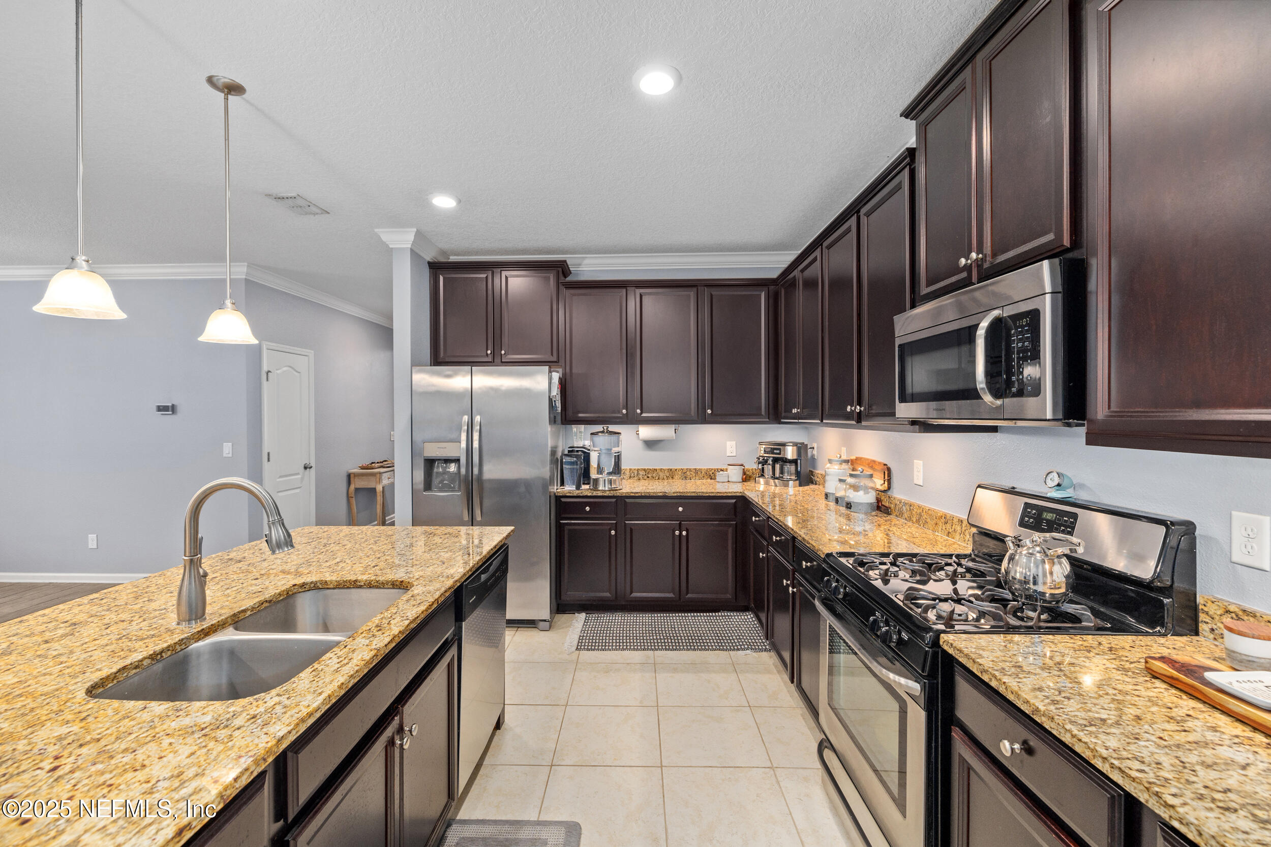 221 St Kitts Loop St. Augustine, FL 32092 - Photo 12 of 44 a kitchen with stainless steel appliances granite countertop a sink stove and refrigerator