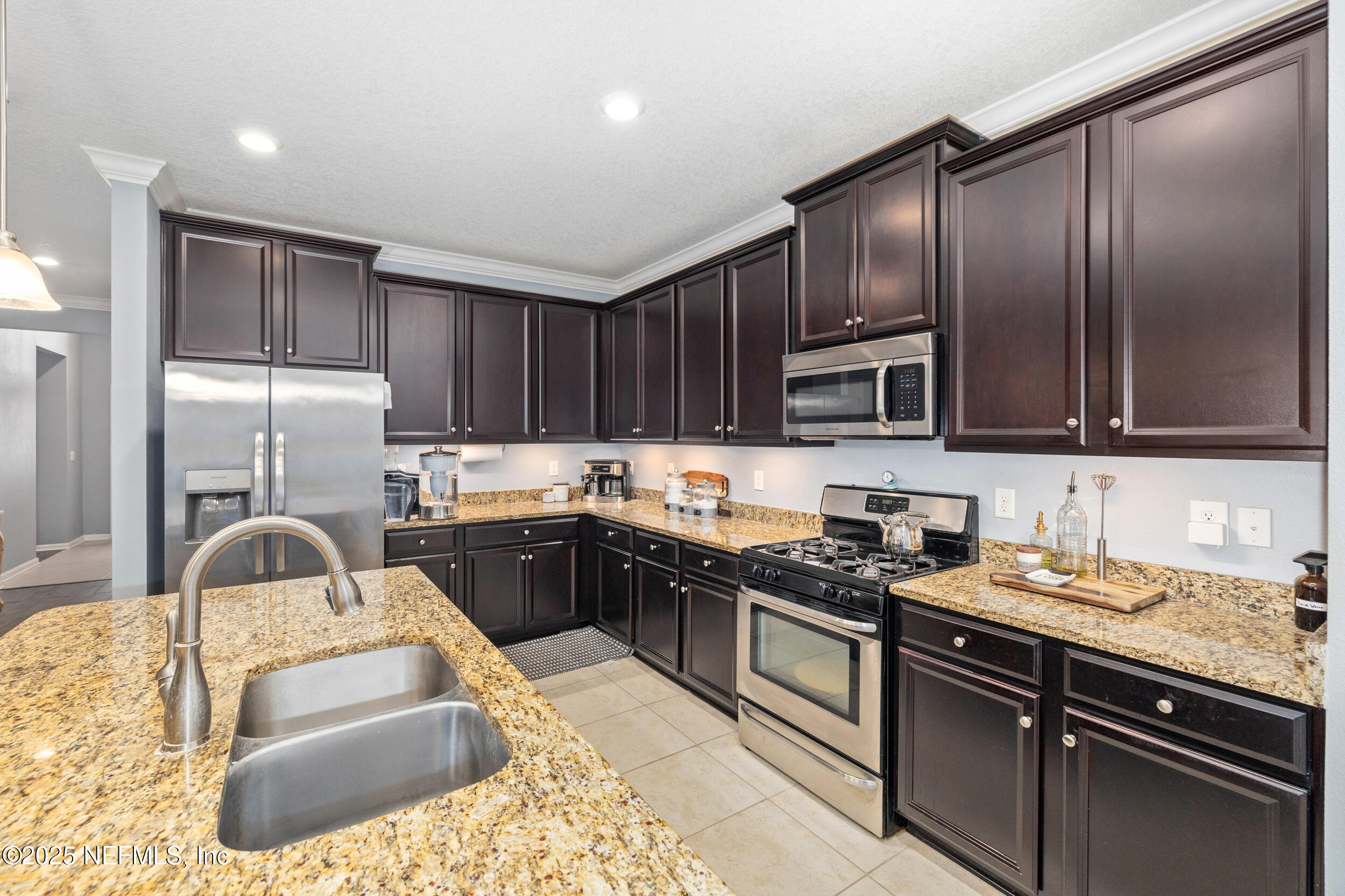 221 St Kitts Loop St. Augustine, FL 32092 - Photo 2 of 44 a kitchen with granite countertop cabinets a sink and stainless steel appliances