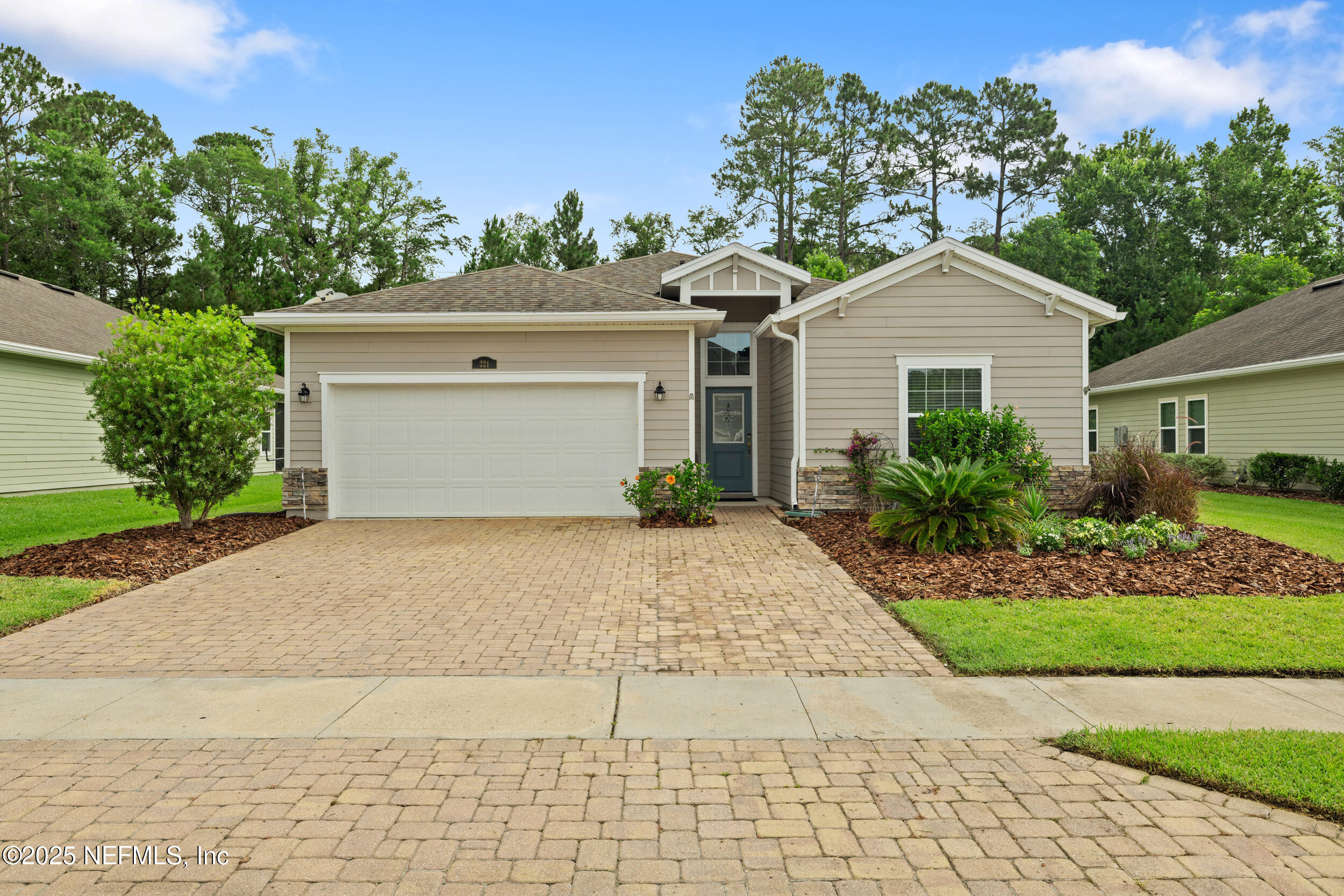 221 St Kitts Loop St. Augustine, FL 32092 - Photo 31 of 44 a front view of a house with a yard and potted plants