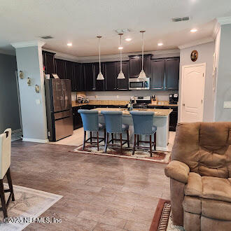 221 St Kitts Loop St. Augustine, FL 32092 - Photo 9 of 44 a kitchen with stainless steel appliances kitchen island granite countertop a table chairs and a refrigerator