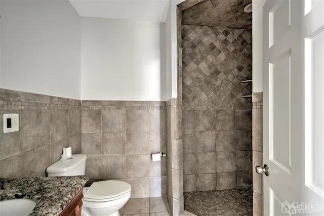 a bathroom with a granite countertop sink a mirror and shower
