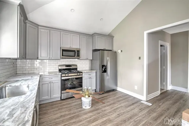 a kitchen with stainless steel appliances granite countertop wooden cabinets a stove a sink and dishwasher