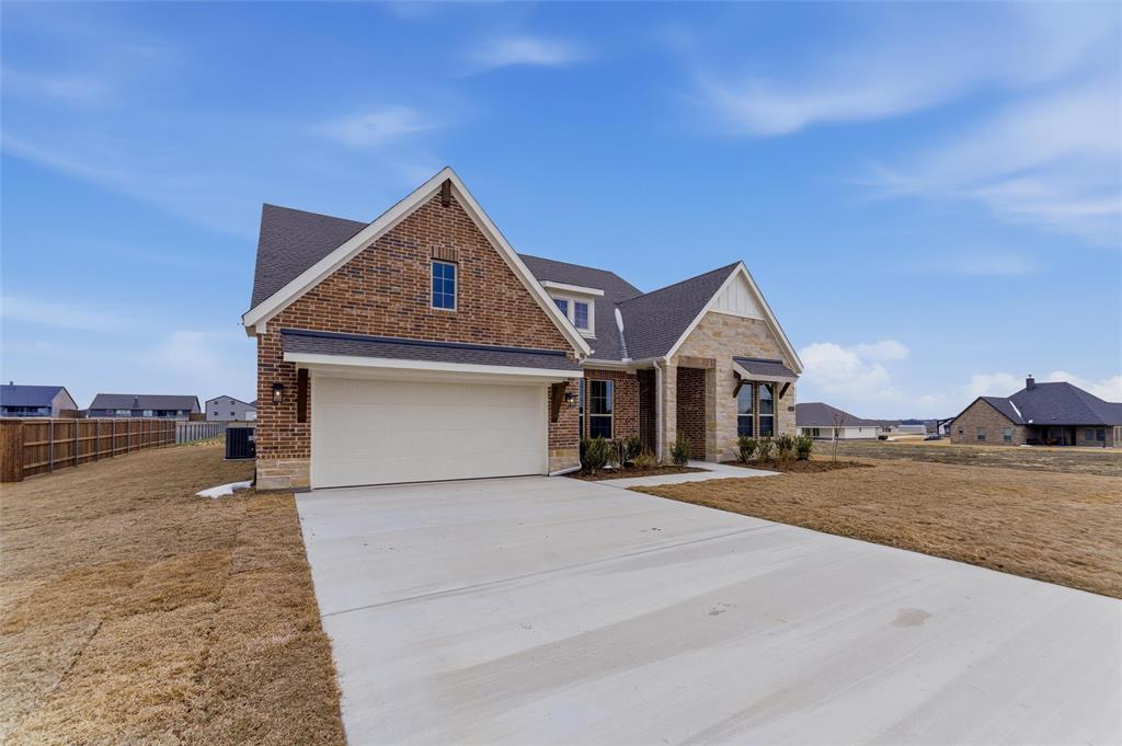114 Brandywine Trail Rhome, TX 76078 - Photo 3 of 27 a front view of a house with a yard and garage