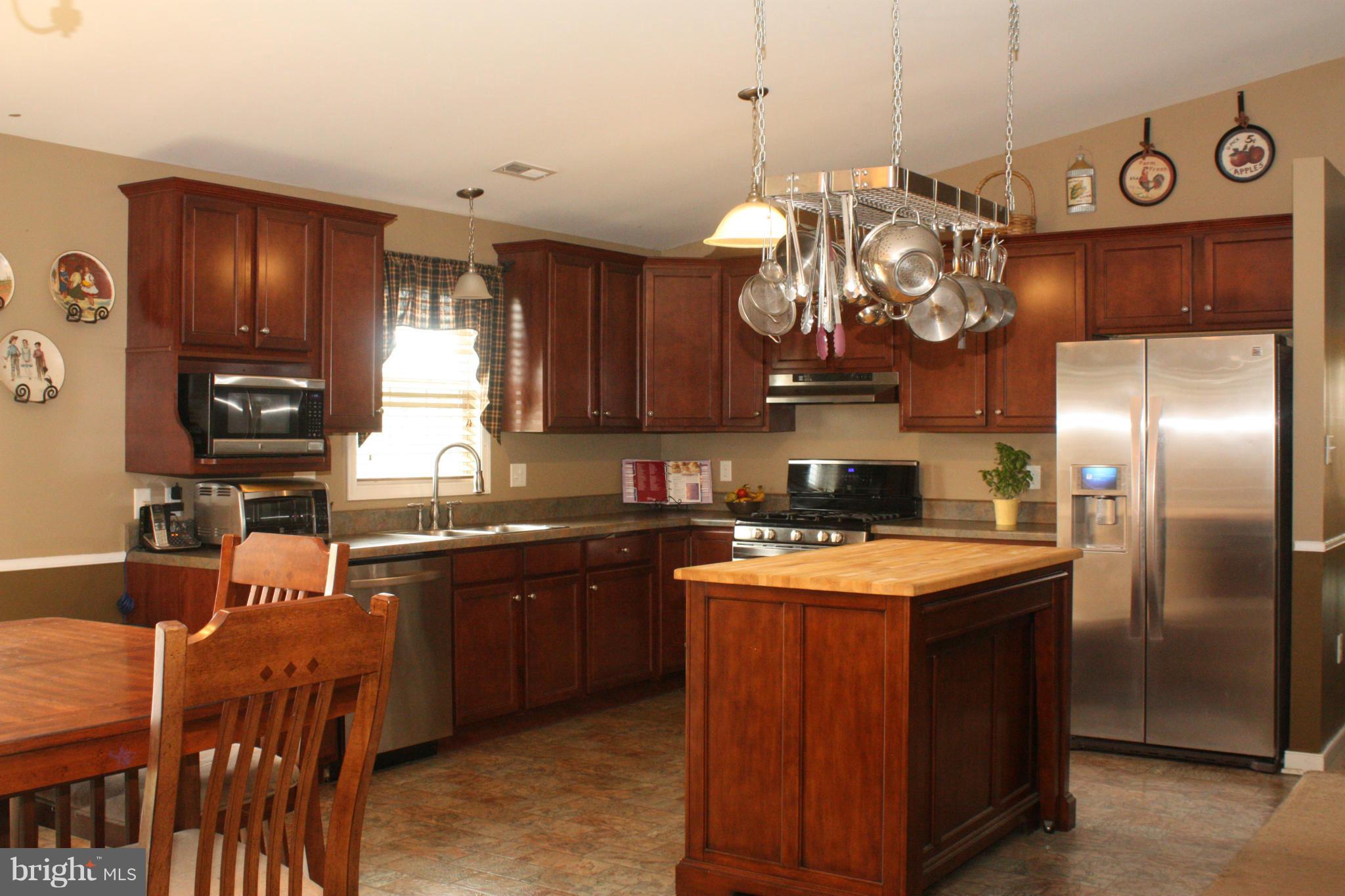 13048 Resh Road Hagerstown, MD 21740 - Photo 5 of 30 a kitchen with stainless steel appliances granite countertop a sink dishwasher a refrigerator a stove and a dining table with wooden floor