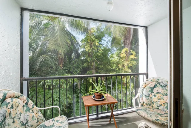a living room with furniture a flat screen tv and floor to ceiling window