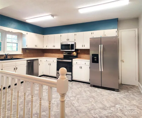 a kitchen with granite countertop a refrigerator and a sink