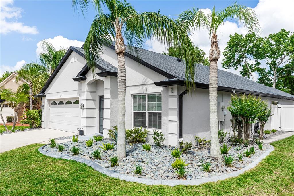 front view of house with a yard and potted plants