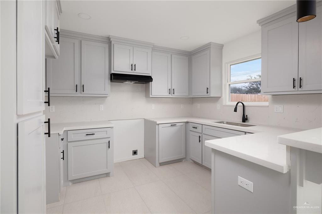 6050 Reymundo Street Edinburg, TX 78542 - Photo 5 of 11 a kitchen with white cabinets and sink