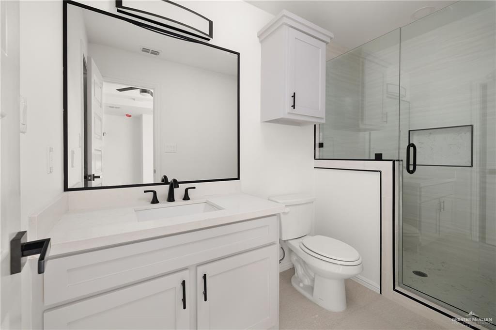 6050 Reymundo Street Edinburg, TX 78542 - Photo 7 of 11 a bathroom with a sink a toilet and a mirror