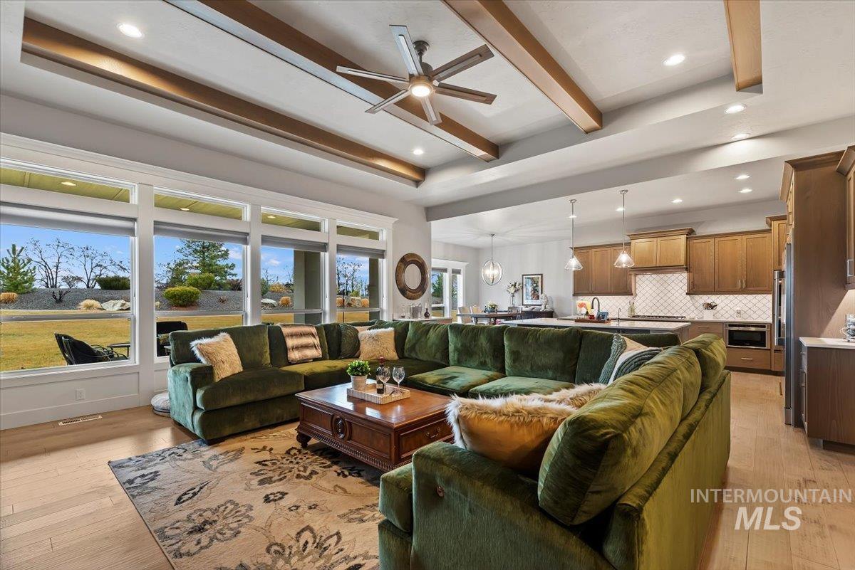 15465 Syrah Court Caldwell, ID 83607 - Photo 11 of 45 Living area featuring recessed lighting, ceiling fan, light wood-type flooring, beam ceiling, and a raised ceiling