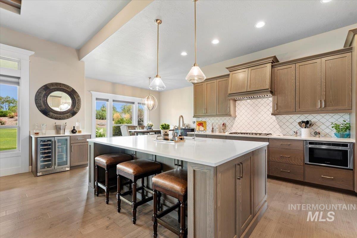 15465 Syrah Court Caldwell, ID 83607 - Photo 13 of 50 Kitchen with wine cooler, tasteful backsplash, light wood-style floors, light countertops, and recessed lighting