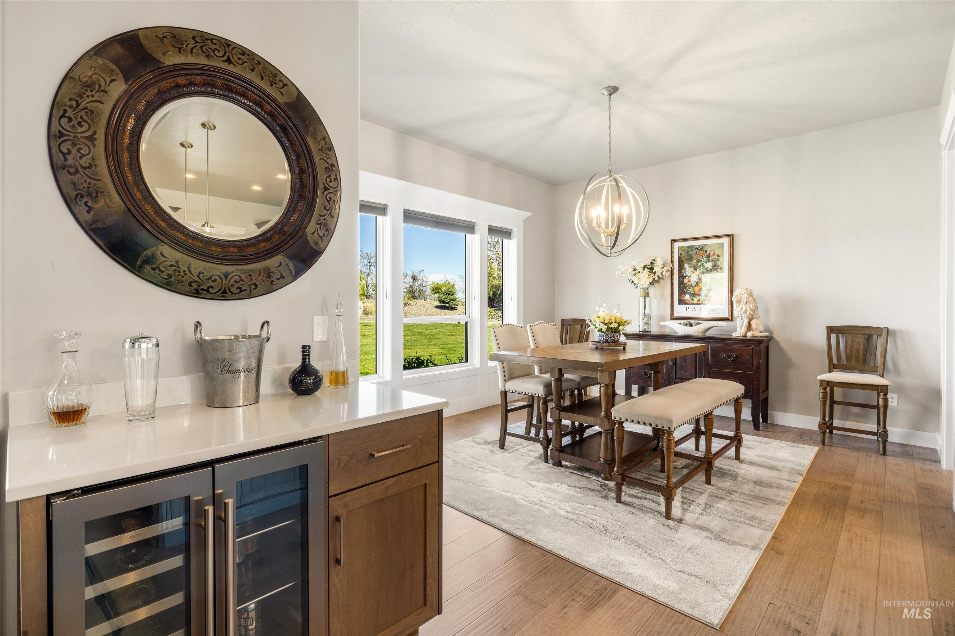 15465 Syrah Court Caldwell, ID 83607 - Photo 17 of 45 Dining area with wine cooler, light wood-type flooring, and suspended lighting
