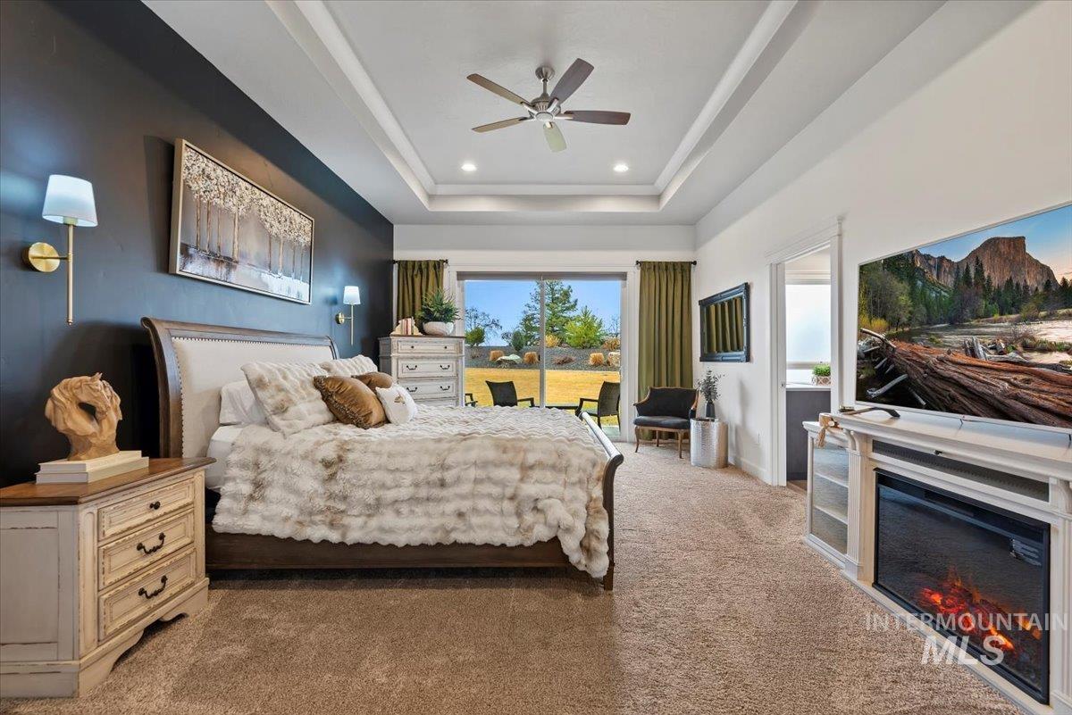 15465 Syrah Court Caldwell, ID 83607 - Photo 18 of 45 Bedroom with ceiling fan, carpet flooring, a glass covered fireplace, and recessed lighting