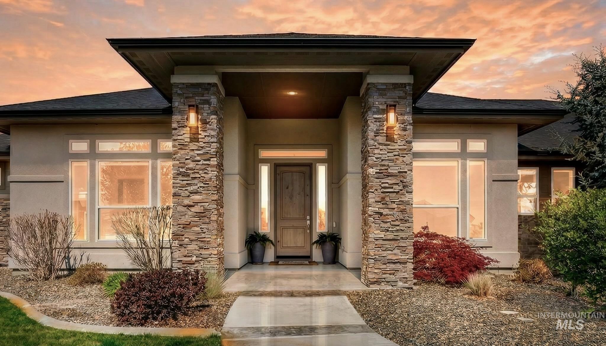 15465 Syrah Court Caldwell, ID 83607 - Photo 2 of 45 Exterior entry at dusk with stone siding and stucco siding