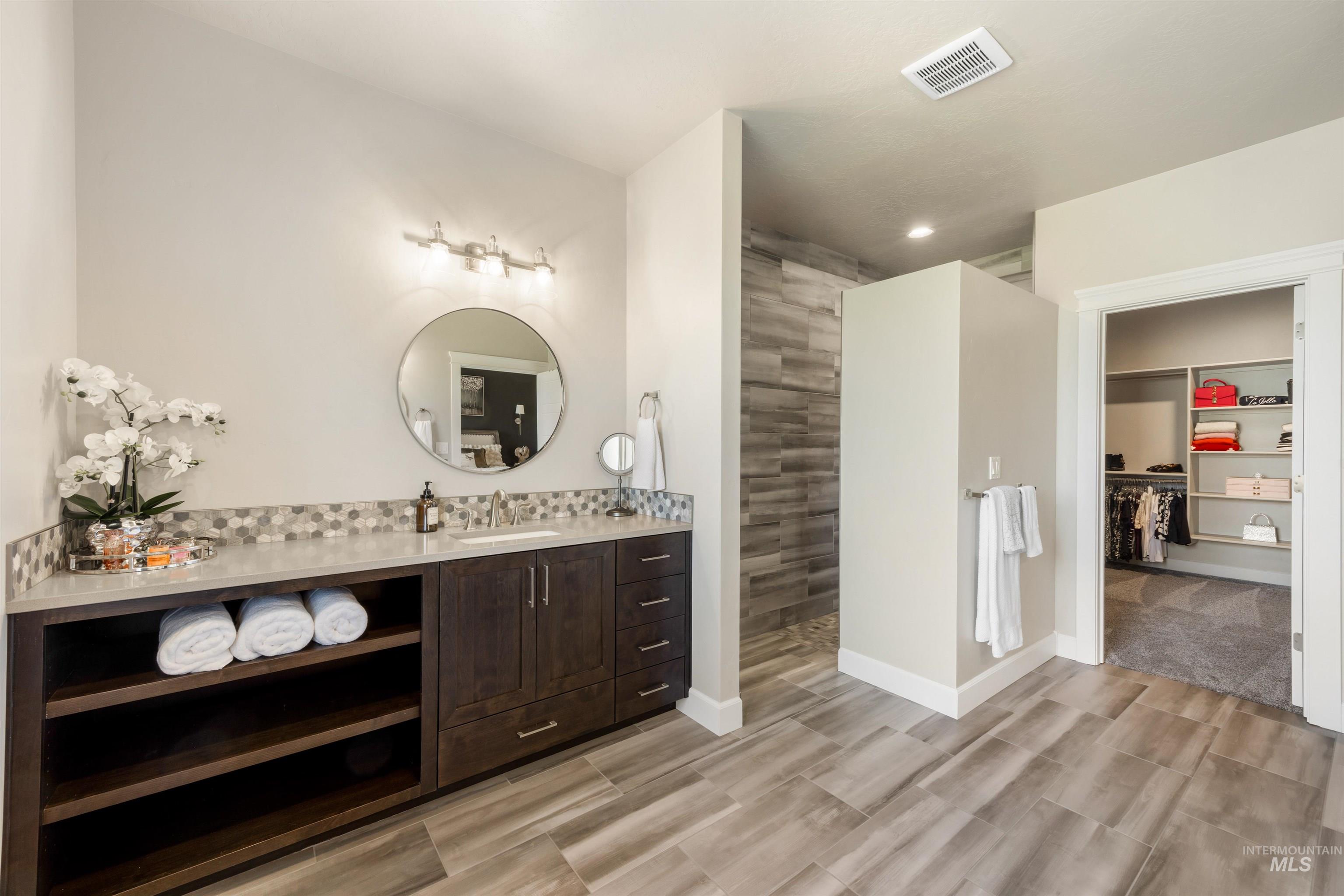 15465 Syrah Court Caldwell, ID 83607 - Photo 21 of 45 Bathroom with vanity, a spacious closet, a walk in shower, and wood finish floors