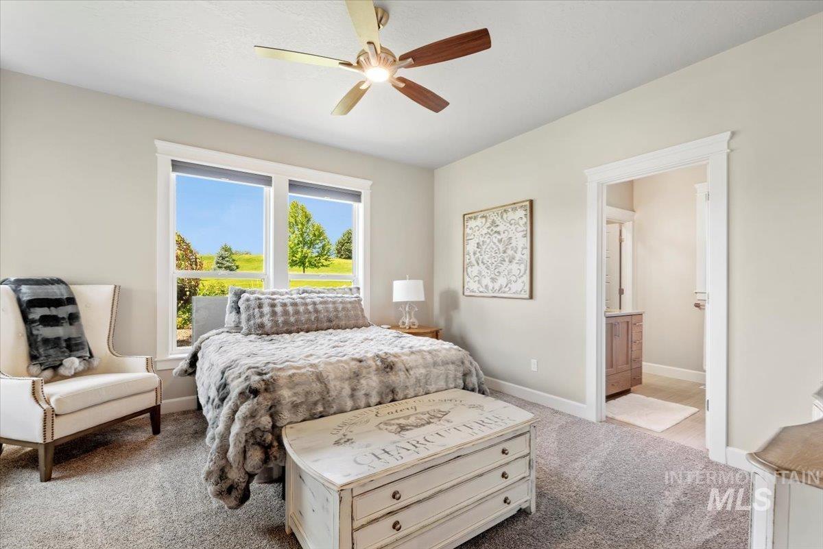 15465 Syrah Court Caldwell, ID 83607 - Photo 23 of 50 Carpeted bedroom featuring ensuite bathroom and ceiling fan