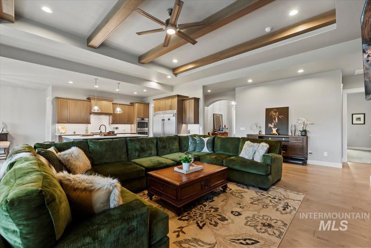 15465 Syrah Court Caldwell, ID 83607 - Photo 3 of 45 Living area featuring arched walkways, a ceiling fan, beam ceiling, recessed lighting, and light wood-style floors