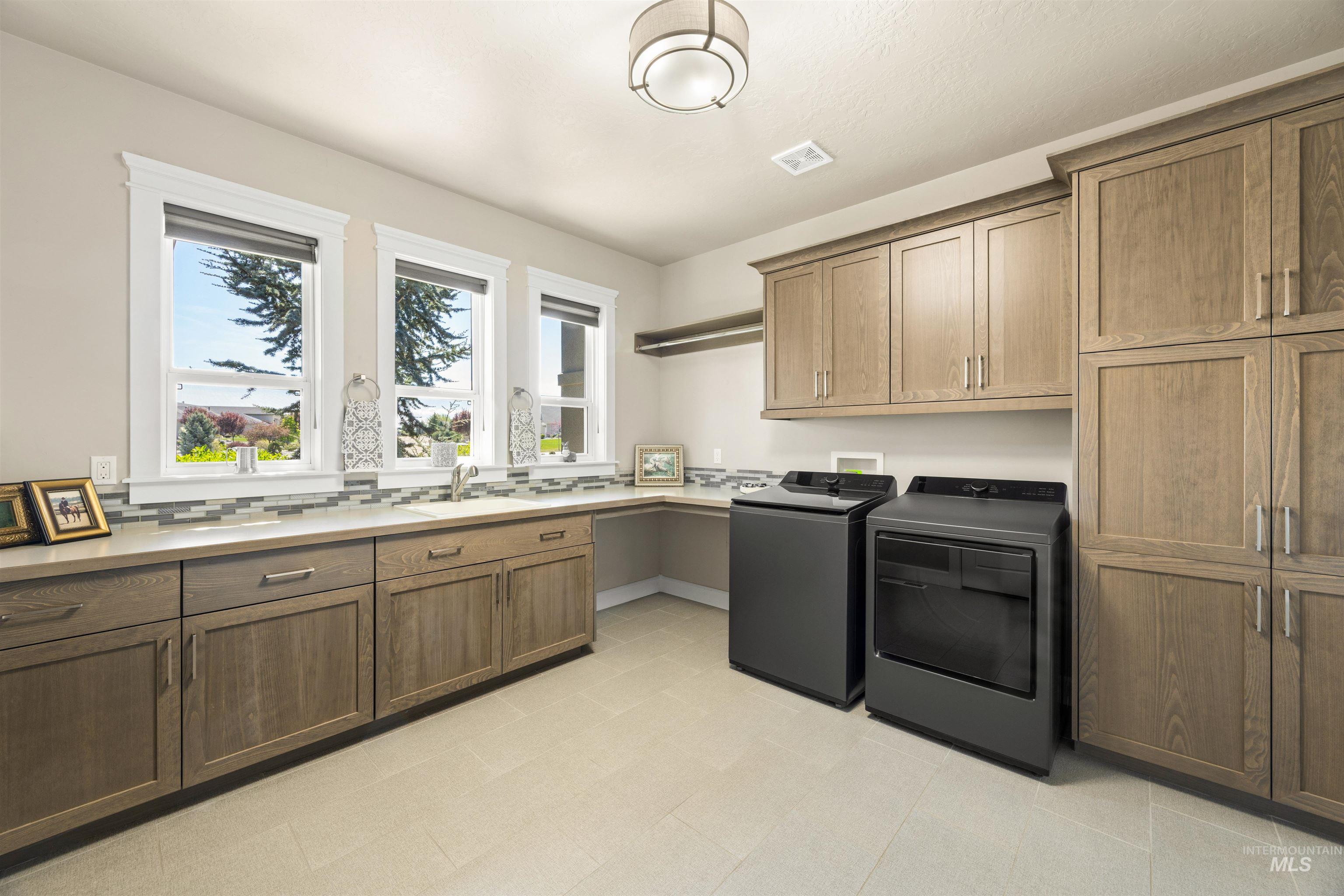 15465 Syrah Court Caldwell, ID 83607 - Photo 31 of 45 Laundry area with cabinet space and washer and clothes dryer