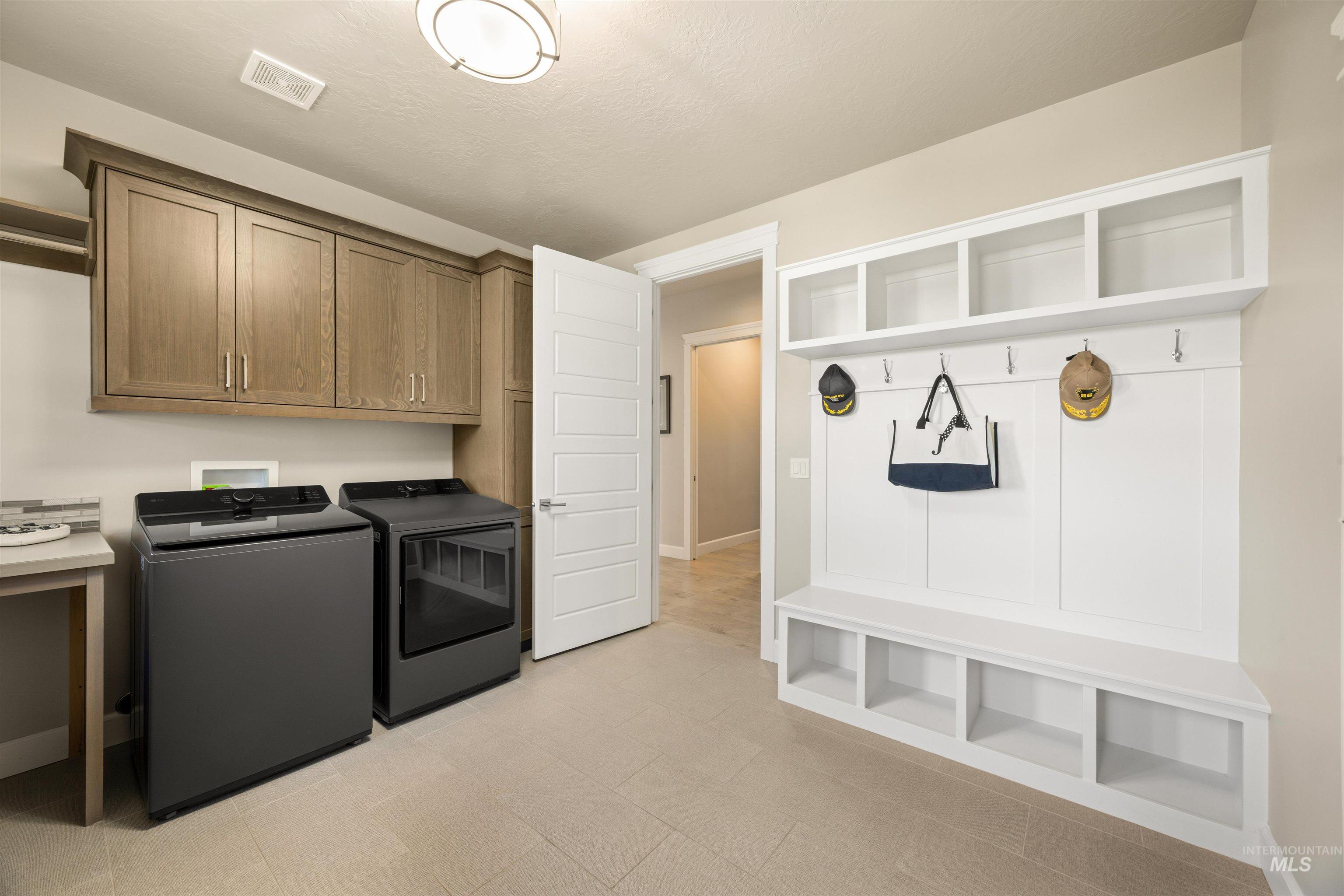 15465 Syrah Court Caldwell, ID 83607 - Photo 32 of 45 Laundry room featuring washing machine and dryer, light flooring, and cabinet space